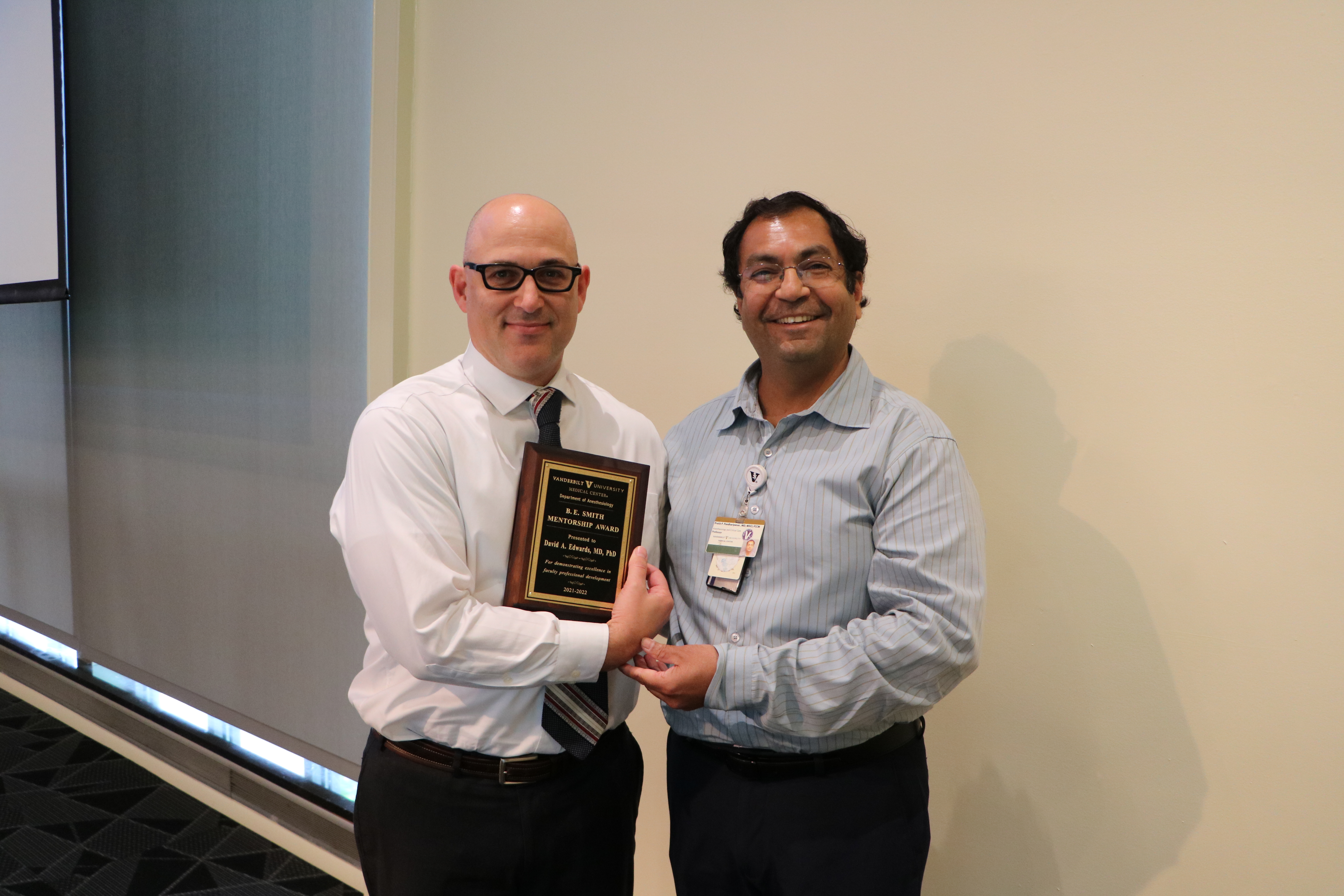 two people holding a plaque