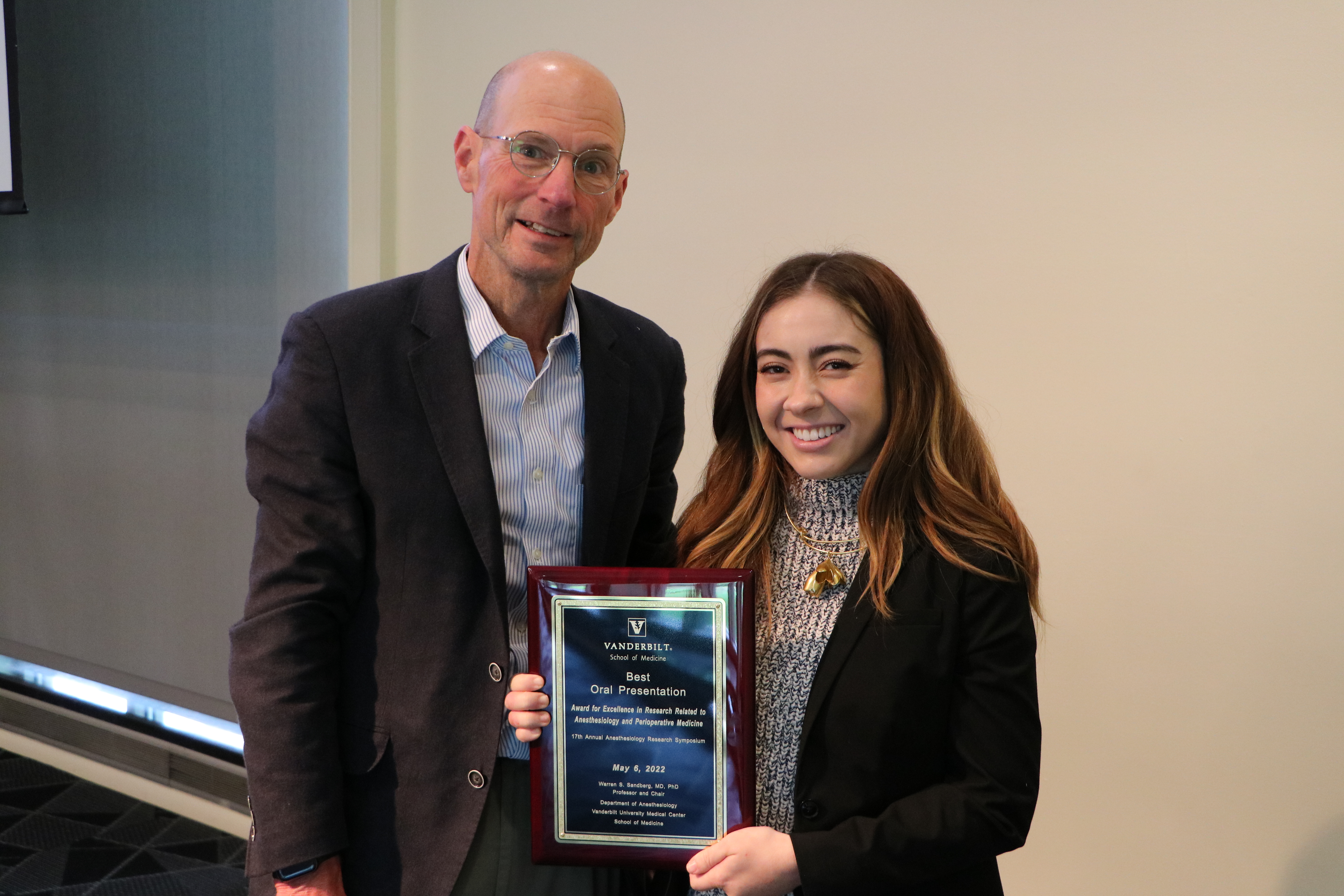 two people holding a plaque