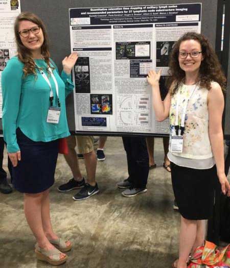 two people presenting a poster at ISMRM