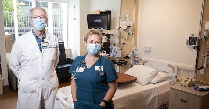 David Haas and Beverly Woodward pose in a treatment room used for COVID-19 research