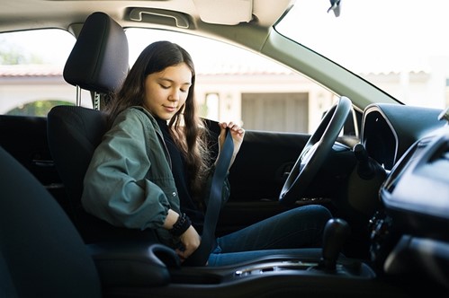 Teen putting on seat belt