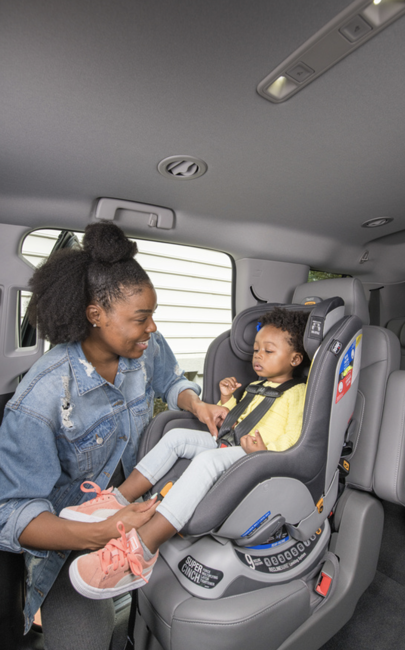 Mom placing child in car seat