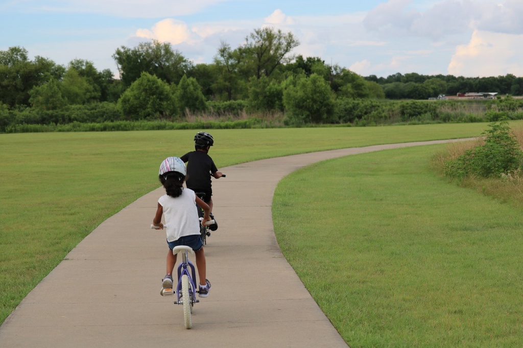 two kids biking with helmets