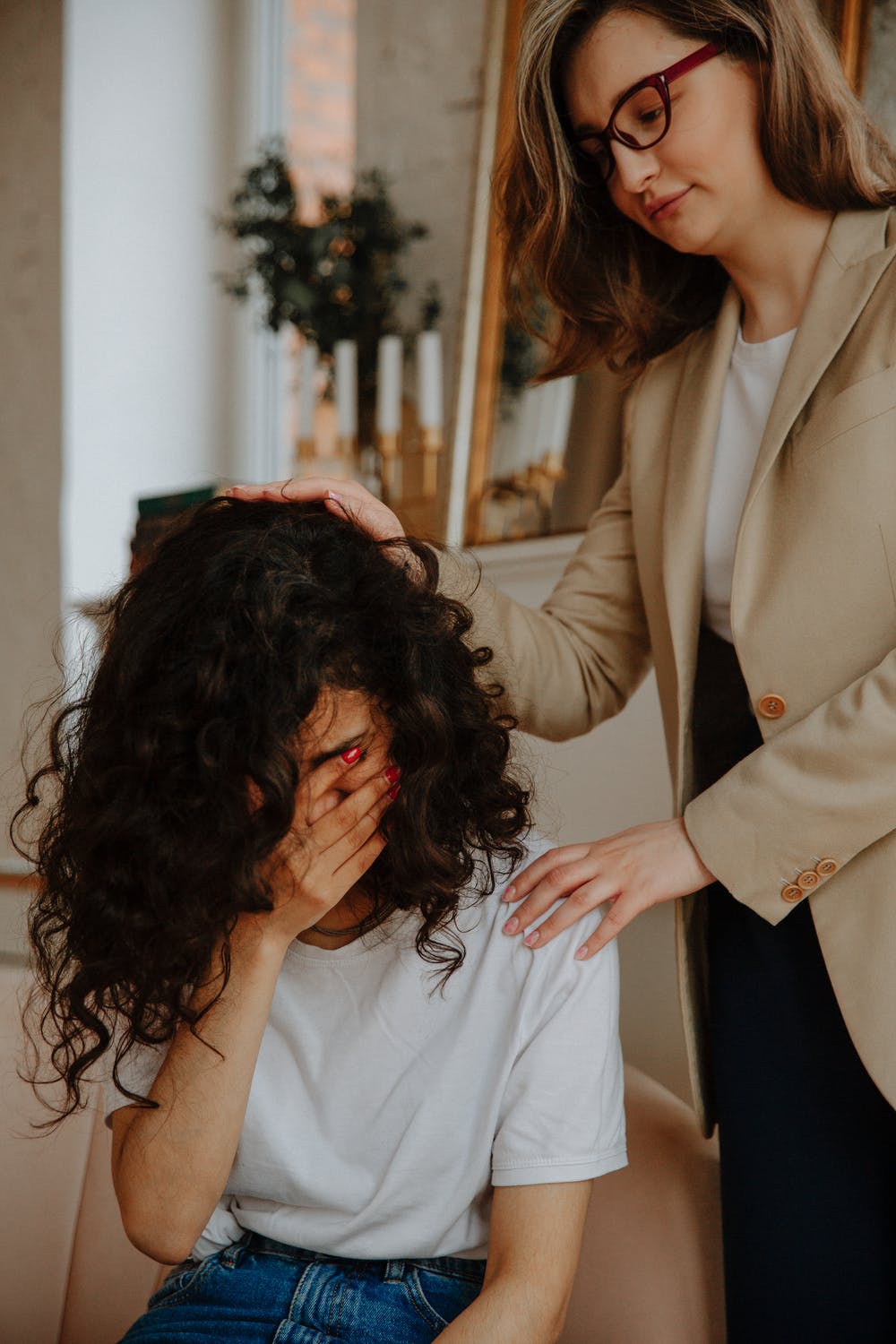 mother comforting teen daughter crying