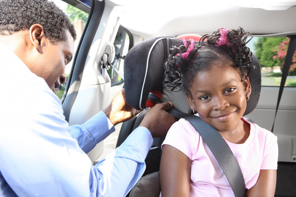 dad helping daughter with car seat