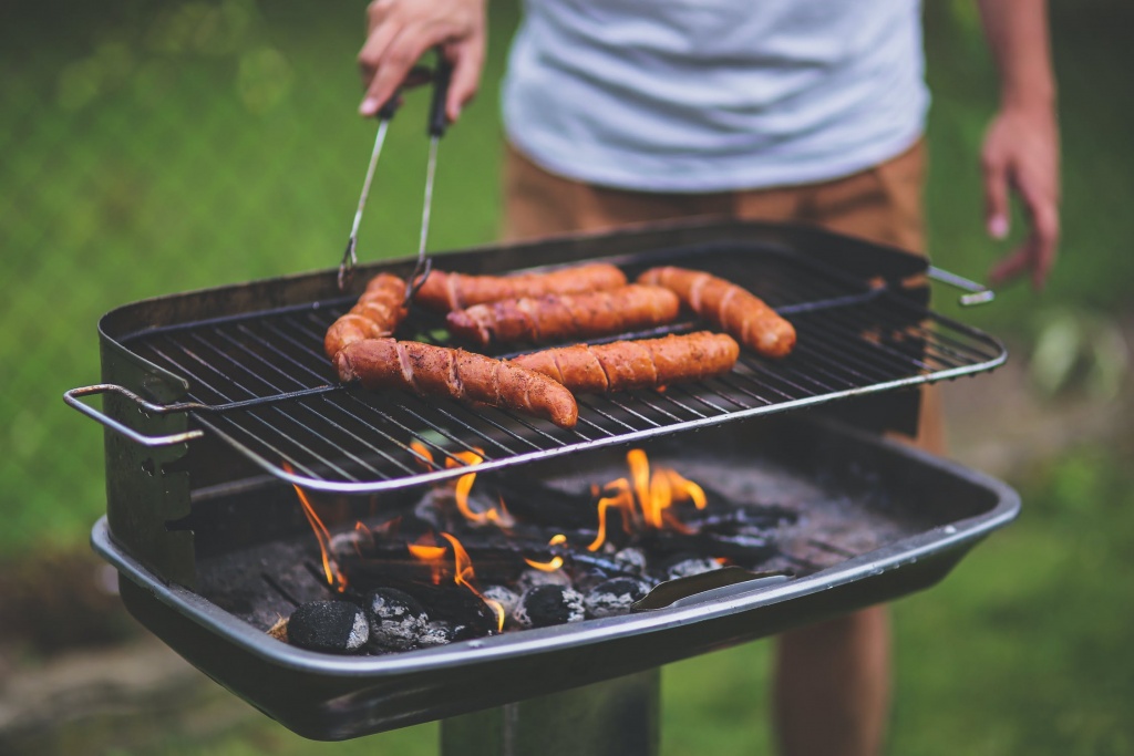 person grilling meat on grill 