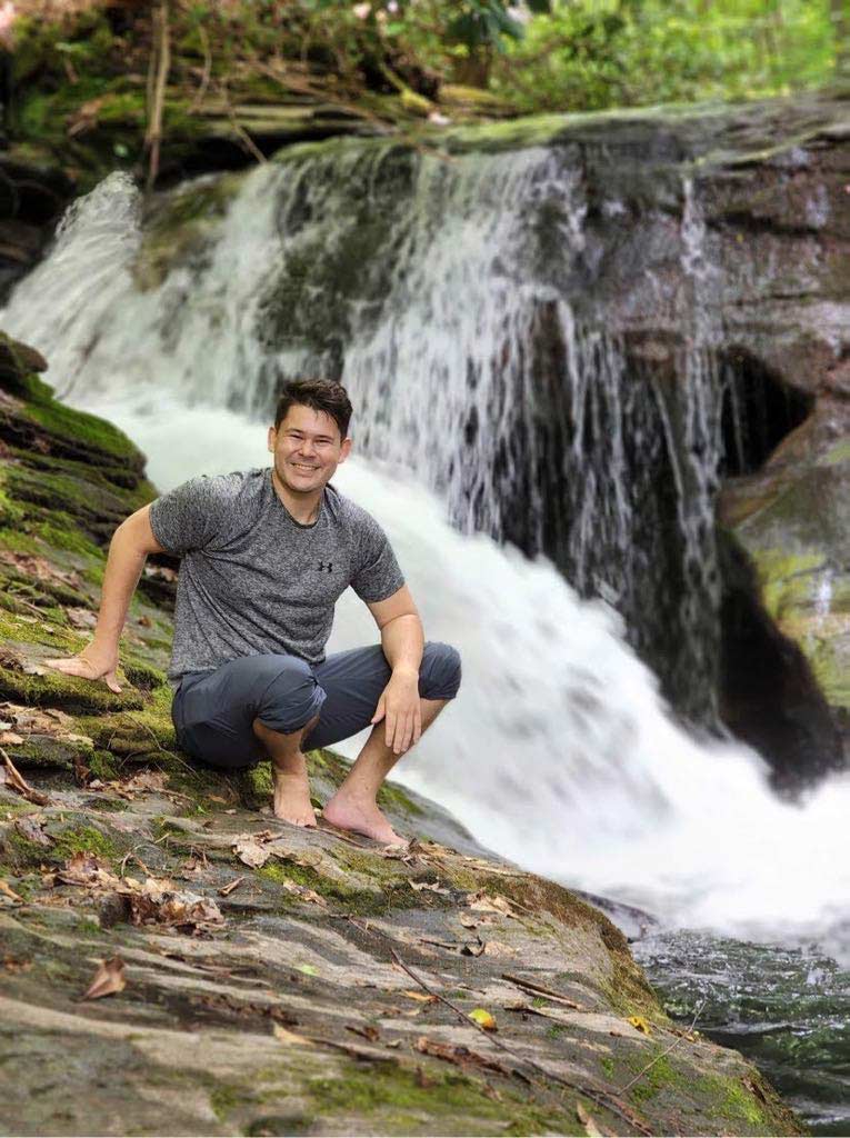 Hunter Hewitt in front of a waterfall