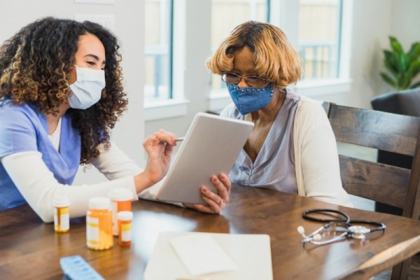 A nurse educates a patient about her medicine.