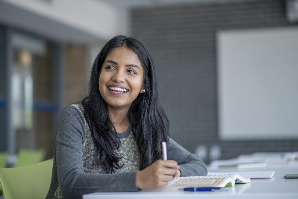 Adult woman smiling and writing